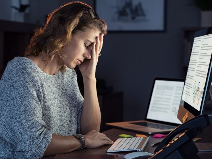 Employee stressed out looking at three screens