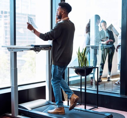HR Employee reviewing ways to improve well-being in the workplace while walking on a treadmill