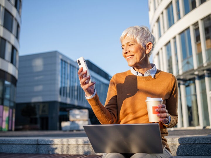 woman practicing work-life balance while outside the office with her laptop and coffee