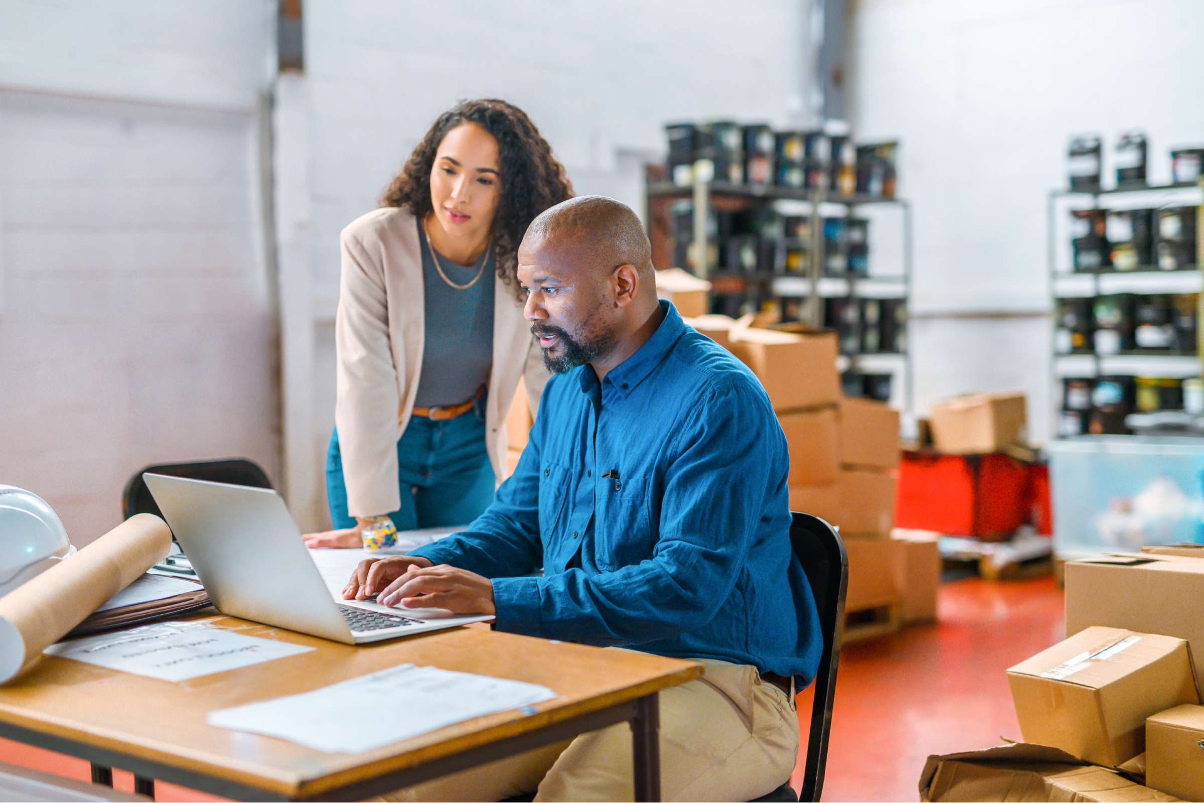 Male and female co-workers looking at a computer